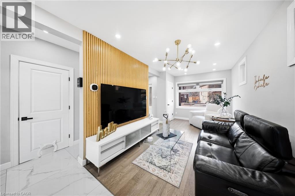 Living room featuring light wood-style flooring and hanging lights - 273 Stinson Crescent, Hamilton, ON - Indoor Photo Showing Living Room
