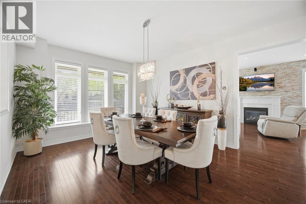 Formal dining area featuring rich wood-finish flooring - 58 Doon Creek Street, Kitchener, ON - Indoor Photo Showing Dining Room With Fireplace