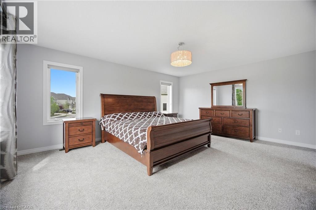 Spacious bedroom featuring light gray walls and plush gray carpeting - 58 Doon Creek Street, Kitchener, ON - Indoor Photo Showing Bedroom