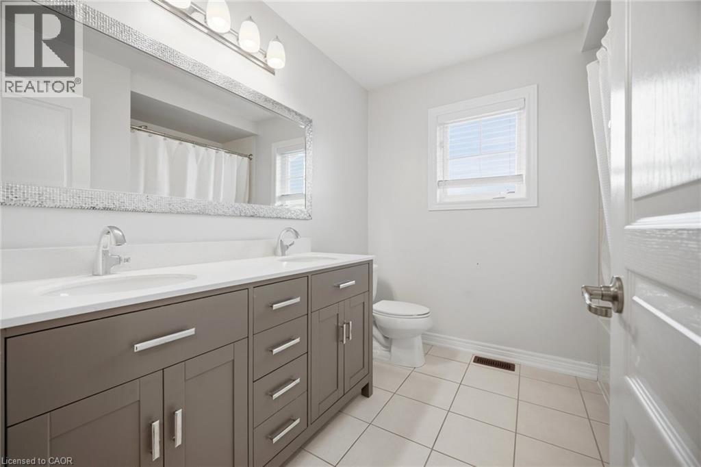 Dual vanity with a white countertop and undermount sinks - 58 Doon Creek Street, Kitchener, ON - Indoor Photo Showing Bathroom