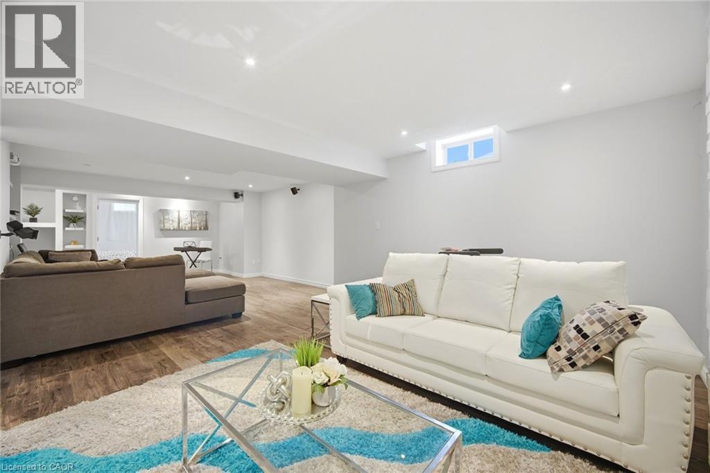 Spacious living area featuring wood-finish flooring, recessed lighting, and a window - 58 Doon Creek Street, Kitchener, ON - Indoor