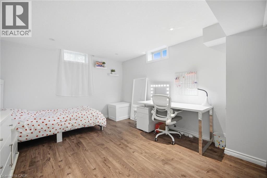 Spacious room featuring wood-finish flooring, white walls, and recessed lighting - 58 Doon Creek Street, Kitchener, ON - Indoor Photo Showing Bedroom