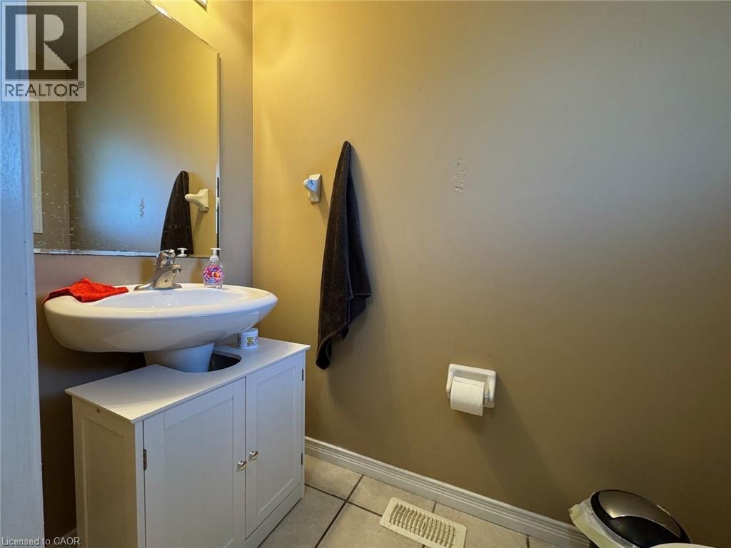 Pedestal sink with chrome faucet, complemented by a white vanity cabinet below - 517 Northbrook Place, Kitchener, ON - Indoor Photo Showing Bathroom