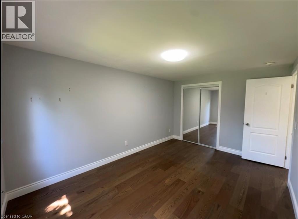 Room featuring wood-finish flooring, light grey walls, white baseboards, and a flush-mount ceiling light - 28 Timberlane Crescent Unit# Upper, Kitchener, ON - Indoor Photo Showing Other Room