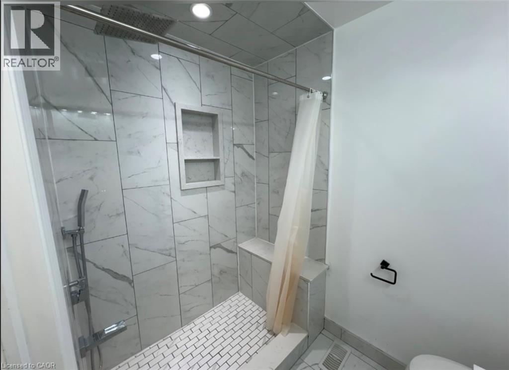 Shower enclosure featuring large format white tile walls with grey veining, a rain showerhead, and a handheld spray attachment - 28 Timberlane Crescent Unit# Upper, Kitchener, ON - Indoor Photo Showing Bathroom