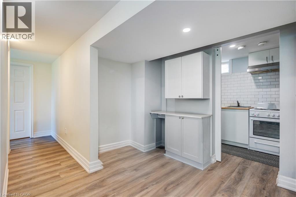 Open-concept area featuring wood-finish flooring, white baseboards, and neutral wall tones - 100 Lauris Avenue, Cambridge, ON - Indoor