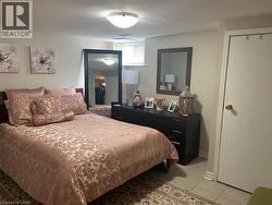 Bedroom featuring a built-in closet with a white door, tile flooring, and a flush mount ceiling light -
