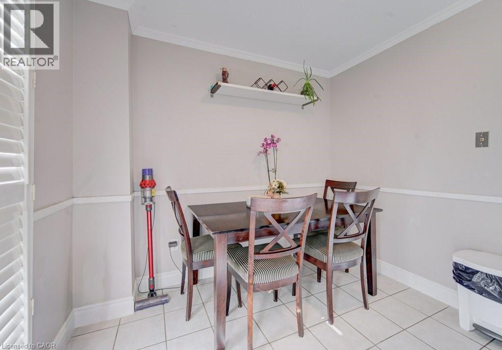 Dining area featuring ceramic tile flooring, crown molding, chair rail molding, and a built-in wall shelf - 334 Christopher Drive, Cambridge, ON - Indoor Photo Showing Dining Room