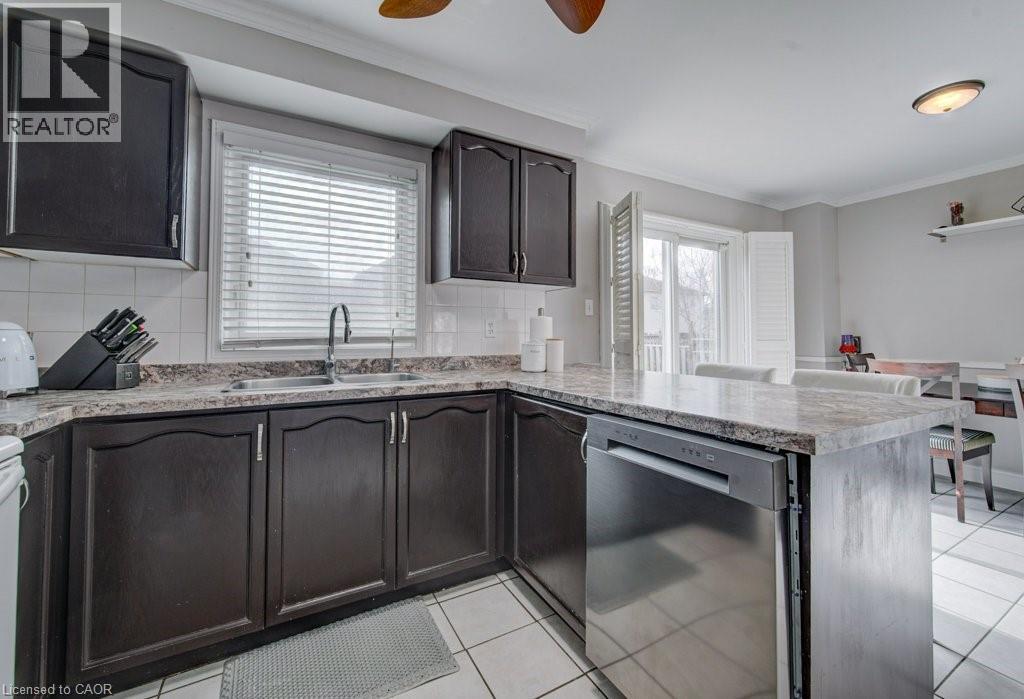 Kitchen featuring dark wood cabinetry, light-colored countertops, and white tile flooring - 334 Christopher Drive, Cambridge, ON - Indoor Photo Showing Kitchen