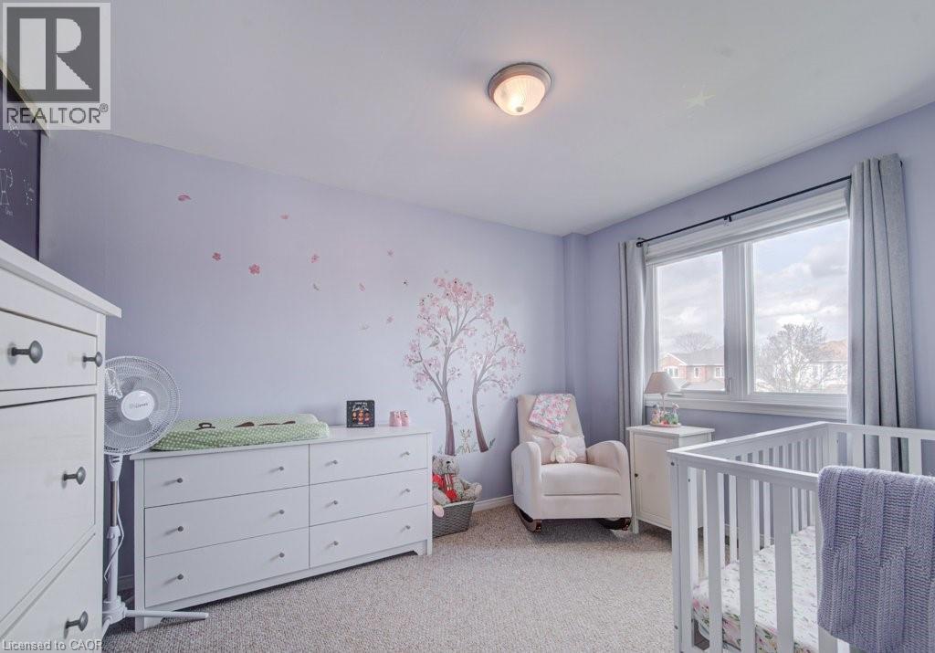 Carpeted room featuring a double window with light-filtering curtains, a flush-mount ceiling light fixture, and walls finished in a light hue - 334 Christopher Drive, Cambridge, ON - Indoor Photo Showing Bedroom