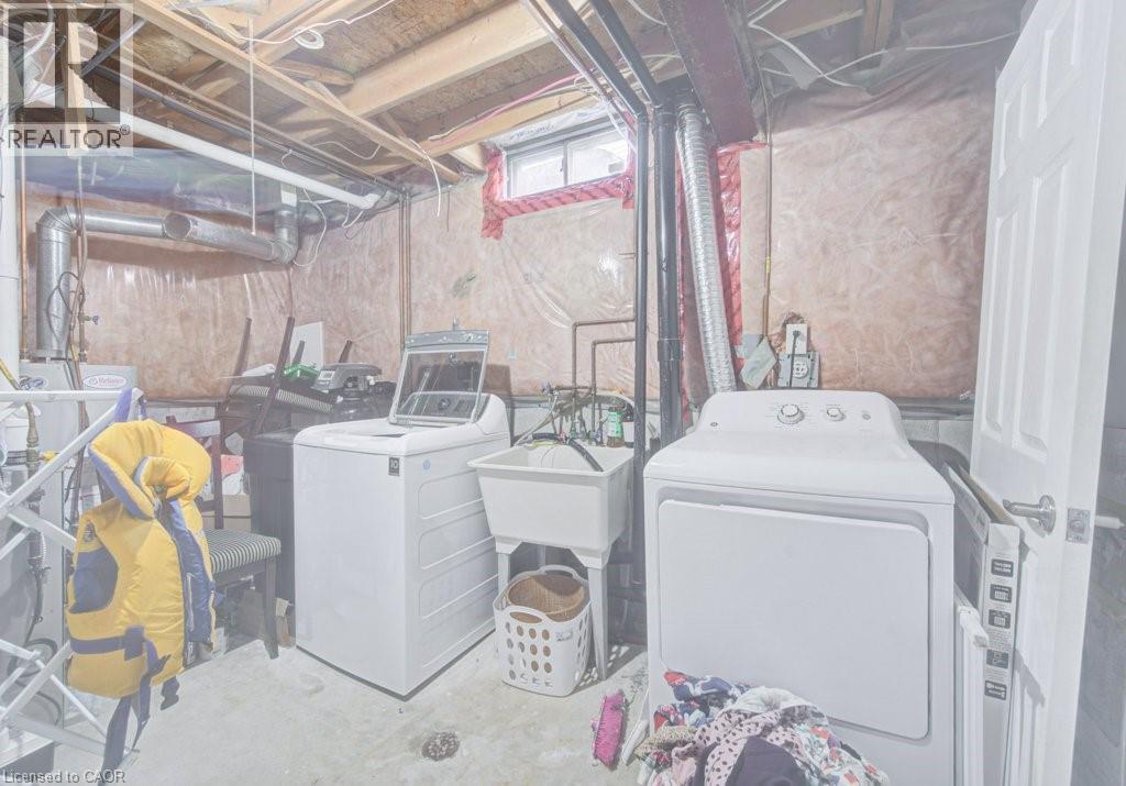 Utility room featuring a laundry sink, exposed wood ceiling joists, and a small window - 334 Christopher Drive, Cambridge, ON - Indoor Photo Showing Laundry Room