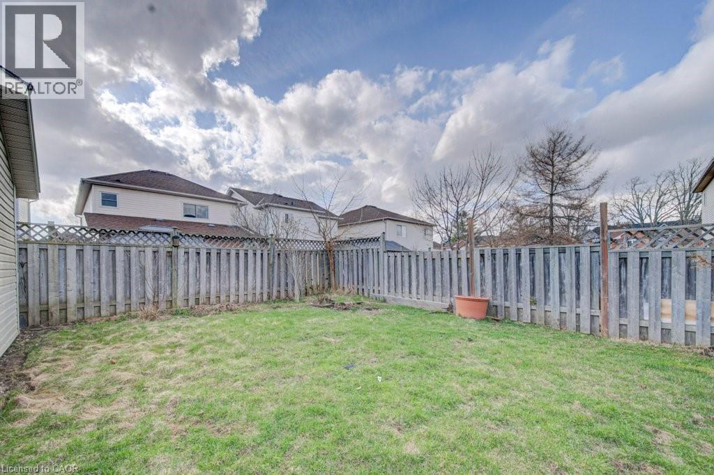 Expansive backyard featuring a lush lawn and perimeter wood fencing - 334 Christopher Drive, Cambridge, ON - Outdoor