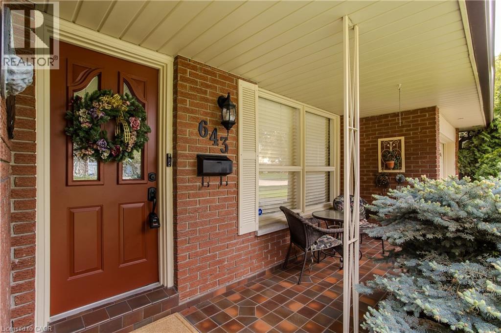 Brick facade featuring a covered front porch with tiled flooring - 643 Artreva Crescent, Burlington, ON - Outdoor With Deck Patio Veranda With Exterior