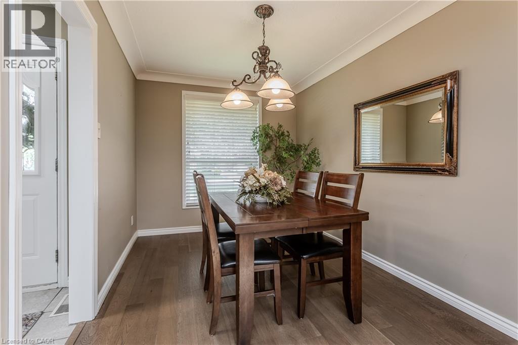 Dining area featuring wood-finish flooring, a window with blinds, and crown molding - 643 Artreva Crescent, Burlington, ON - Indoor Photo Showing Dining Room