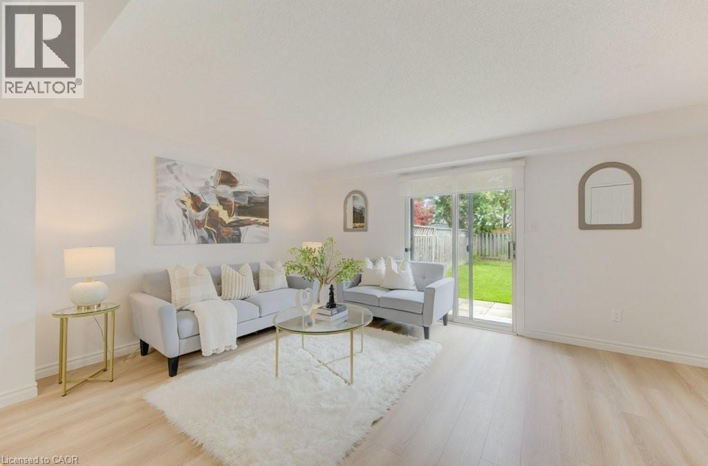 Light wood-finish flooring complements the neutral wall tones - 603 Pinerow Crescent Unit# B, Waterloo, ON - Indoor Photo Showing Living Room