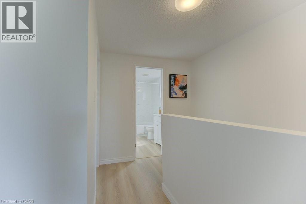 Hallway featuring wood-finish flooring, white walls, and a recessed ceiling light fixture - 603 Pinerow Crescent Unit# B, Waterloo, ON - Indoor Photo Showing Other Room