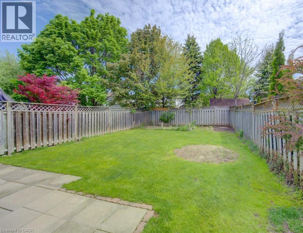 Expansive backyard with a manicured lawn, established perimeter fencing, and mature trees providing natural screening - 603 Pinerow Crescent Unit# B, Waterloo, ON - Outdoor With Backyard