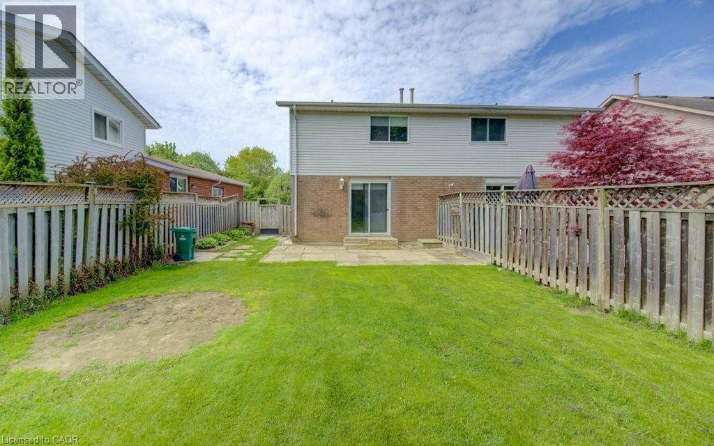 Expansive green lawn with a patio area, privacy fencing, and mature perimeter trees - 603 Pinerow Crescent Unit# B, Waterloo, ON - Outdoor