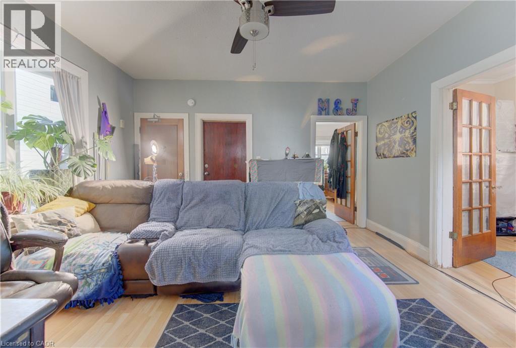 Living area featuring light wood-finish flooring, light blue wall paint, a ceiling fan, and white trim - 48 Breithaupt Street, Kitchener, ON - Indoor Photo Showing Living Room
