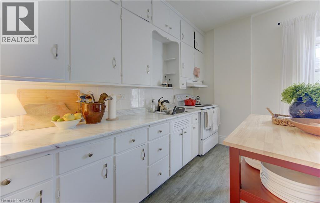 Upper unit kitchen featuring white cabinetry and light-colored countertops - 48 Breithaupt Street, Kitchener, ON - Indoor Photo Showing Kitchen