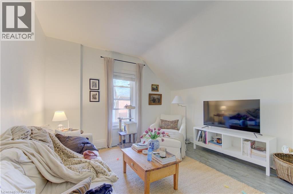 Attic living space featuring a window with natural light, light-toned walls, wood-finish flooring, and a sloped ceiling - 48 Breithaupt Street, Kitchener, ON - Indoor Photo Showing Living Room