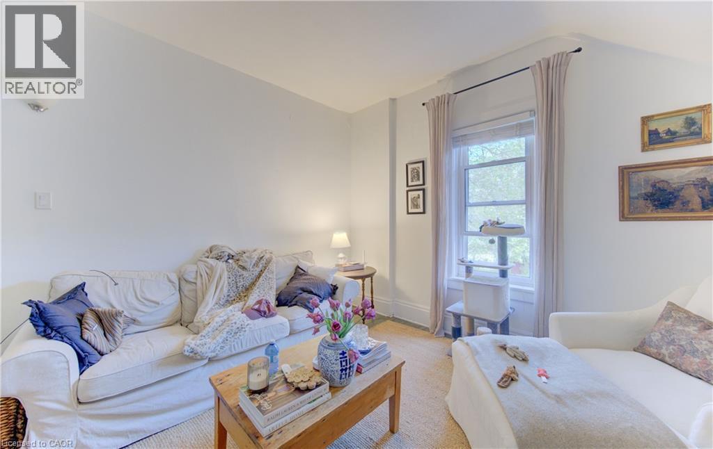 Bright interior space featuring a window with natural light, light-colored walls, and a wall-mounted sconce - 48 Breithaupt Street, Kitchener, ON - Indoor