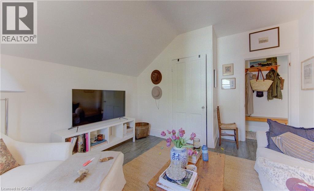 Interior space featuring a vaulted ceiling, wood-finish flooring, white walls, and a built-in entryway bench with shelving and hooks - 48 Breithaupt Street, Kitchener, ON - Indoor Photo Showing Living Room