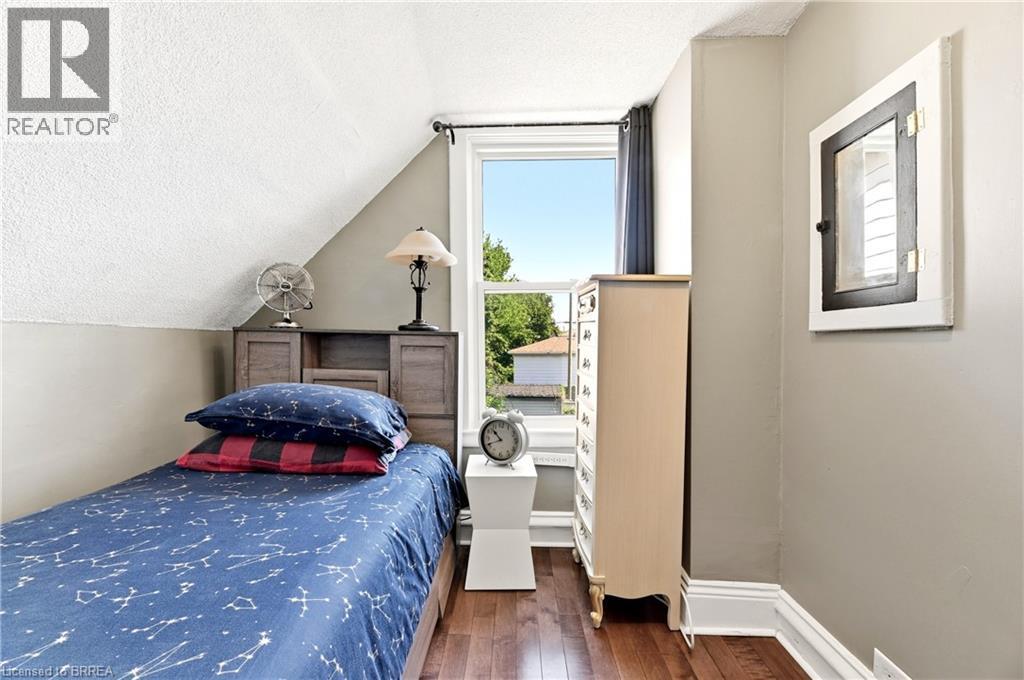 Hardwood-finish flooring complementing neutral wall tones - 23 Britannia Avenue, Hamilton, ON - Indoor Photo Showing Bedroom