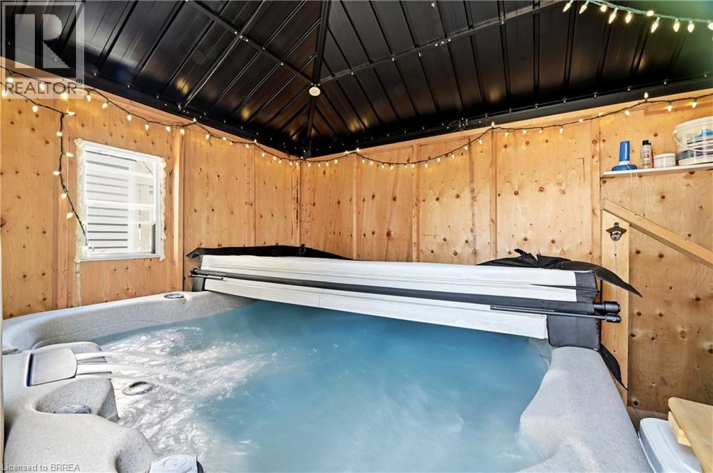 Enclosed hot tub area featuring wood paneling, a black metal roof structure, and a functional window - 23 Britannia Avenue, Hamilton, ON - Indoor