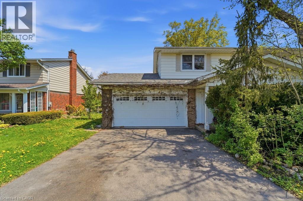 Concrete driveway leading to an attached garage with a white panel door - 46 Birchcliff Avenue, Kitchener, ON - Outdoor