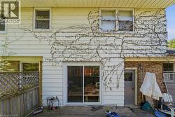 Rear exterior featuring white horizontal siding and a full-light sliding patio door -