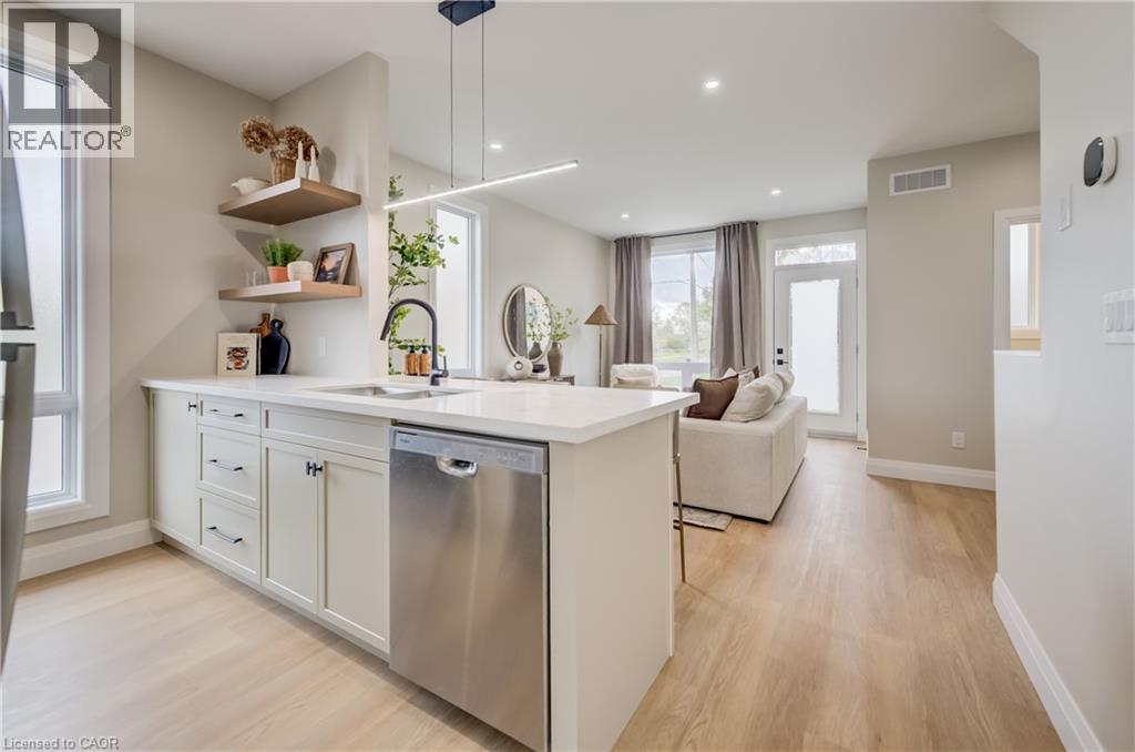 Modern kitchen featuring a white countertop island with an undermount sink and a stainless steel dishwasher - 210 Heritage Drive Unit# Main, Kitchener, ON - Indoor Photo Showing Kitchen