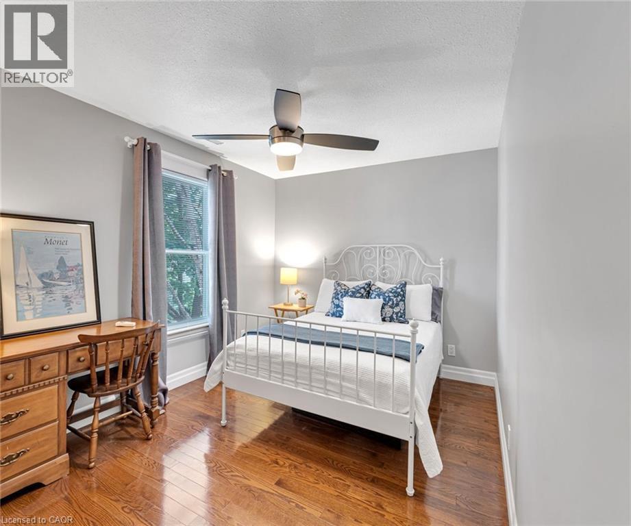 Room featuring wood-finish flooring, a window with trim, a ceiling fan with integrated lighting, and light-toned wall finishes - 546 Hurd Avenue, Burlington, ON - Indoor Photo Showing Bedroom