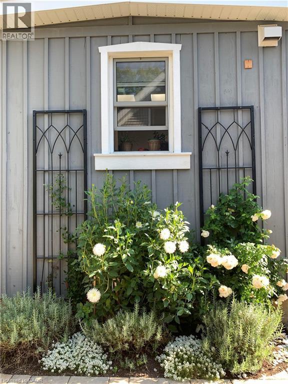 Vertical panel siding with a single-hung window featuring white trim and a window box - 546 Hurd Avenue, Burlington, ON - Outdoor