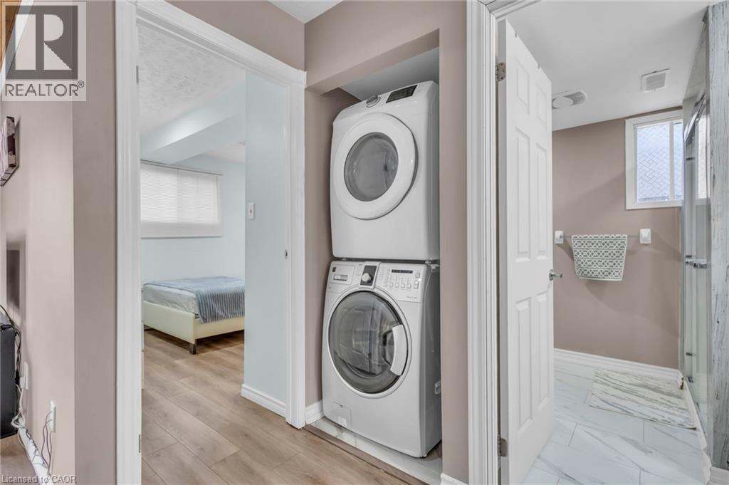 Laundry area with healthy amount of natural light and stacked washer and dryer - 146 Bechtel Drive, Kitchener, ON - Indoor Photo Showing Laundry Room