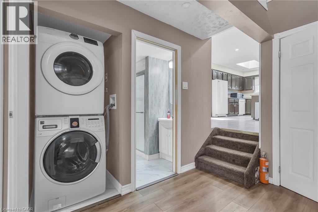 Laundry area featuring stacked washer and clothes dryer, light wood-style flooring, and recessed lighting - 146 Bechtel Drive, Kitchener, ON - Indoor Photo Showing Laundry Room