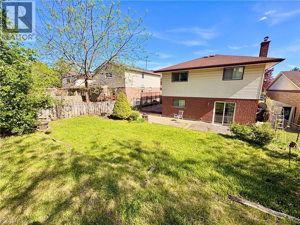 Expansive lawn area with a tiered design, mature trees, and privacy fencing - 146 Bechtel Drive, Kitchener, ON - Outdoor