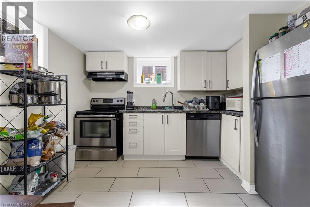 Kitchen featuring white cabinetry, dark countertops, a stainless steel range, a stainless steel dishwasher, and tile flooring - 46 Beaconsfield Drive, Hamilton, ON - Indoor Photo Showing Kitchen