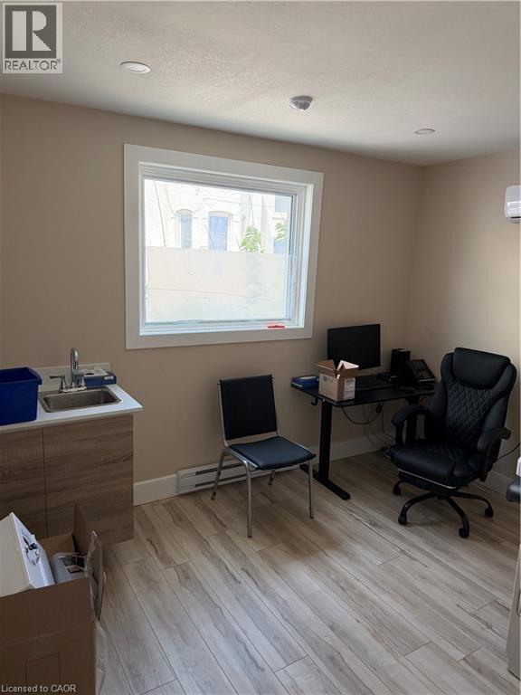 Spacious room featuring wood-finish flooring and neutral wall tones - 357 Main Street E Unit# Main Floor, Hamilton, ON