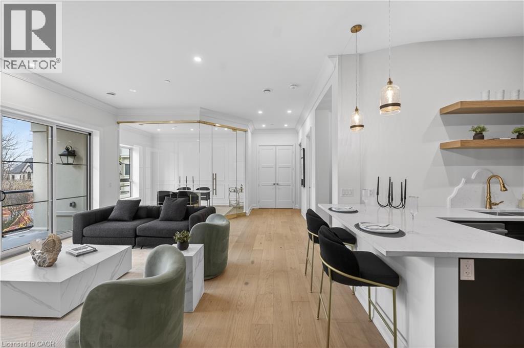Open-concept living area featuring light wood-finish flooring and recessed lighting throughout - 2 Arbourvale Common Unit# 209, St. Catharines, ON - Indoor
