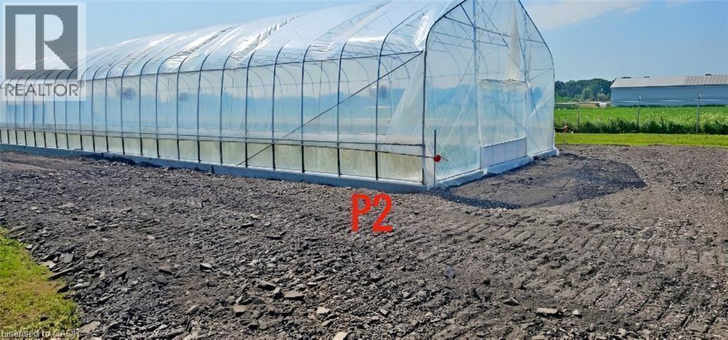 Long, clear-span greenhouse structure with a sturdy frame, translucent covering, and a concrete foundation - 96 Second Road E, Stoney Creek, ON