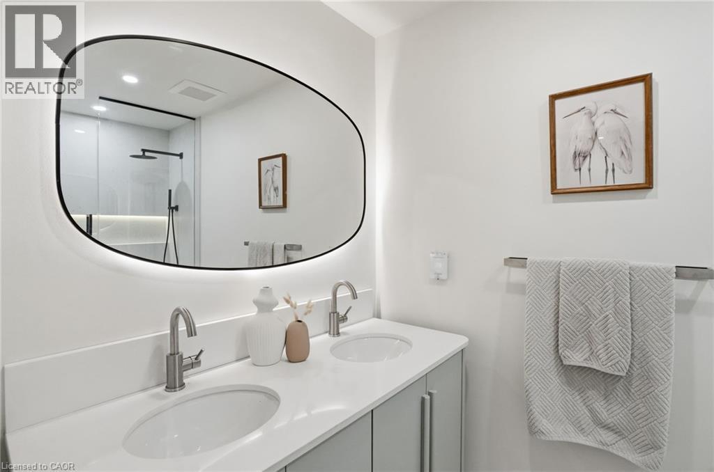 Modern bathroom featuring a dual vanity with undermount sinks, brushed nickel faucets, and a white countertop - 345 Rankin Drive, Burlington, ON - Indoor Photo Showing Bathroom