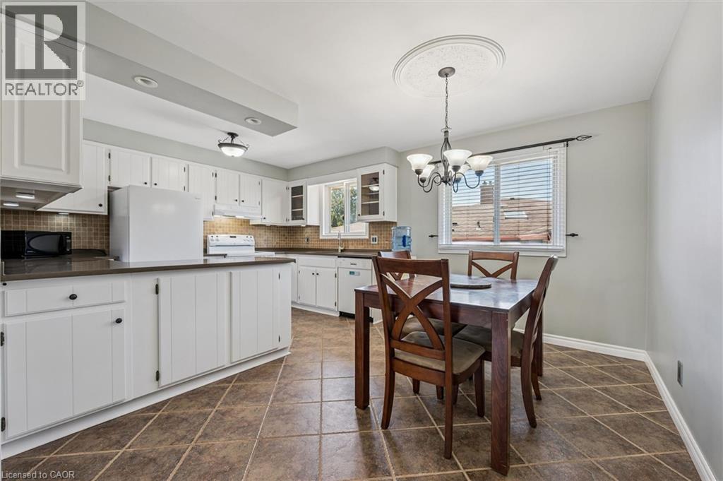 Kitchen featuring white cabinetry, dark countertops, tiled backsplash, and recessed lighting - 47 Oakhurst Crescent, Kitchener, ON - Indoor