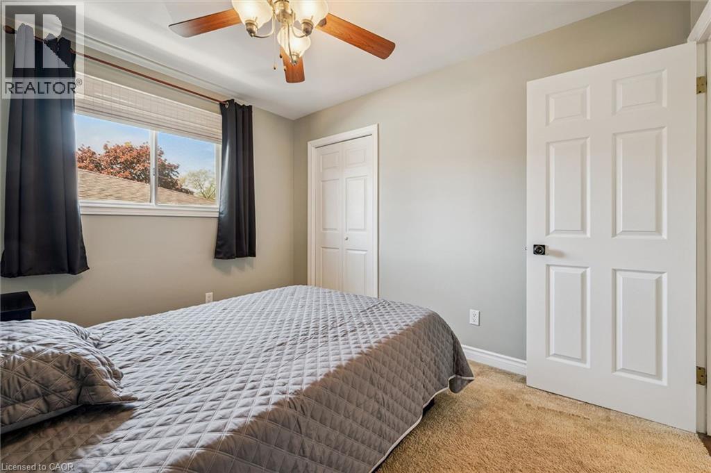Carpeted bedroom with a window featuring horizontal blinds - 47 Oakhurst Crescent, Kitchener, ON - Indoor Photo Showing Bedroom