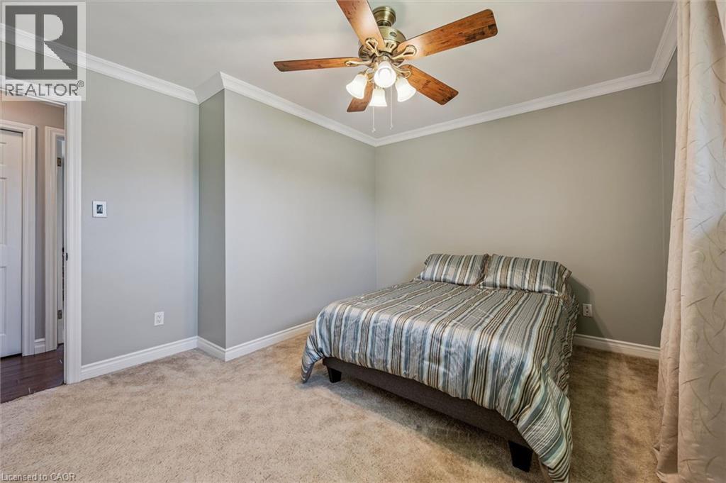Bedroom featuring neutral wall paint, carpet flooring, crown molding, and a ceiling fan with integrated lighting - 47 Oakhurst Crescent, Kitchener, ON - Indoor Photo Showing Bedroom