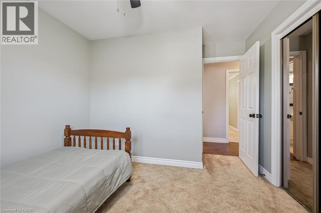 Soft neutral wall paint with white trim, plush carpeting, and an overhead ceiling fan - 47 Oakhurst Crescent, Kitchener, ON - Indoor Photo Showing Bedroom
