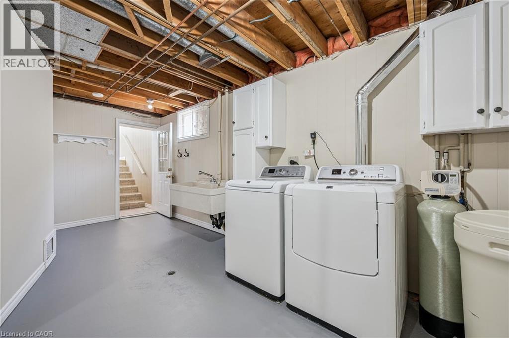 Dedicated laundry area featuring a washer and dryer, utility sink, and wall-mounted cabinetry - 47 Oakhurst Crescent, Kitchener, ON - Indoor Photo Showing Laundry Room