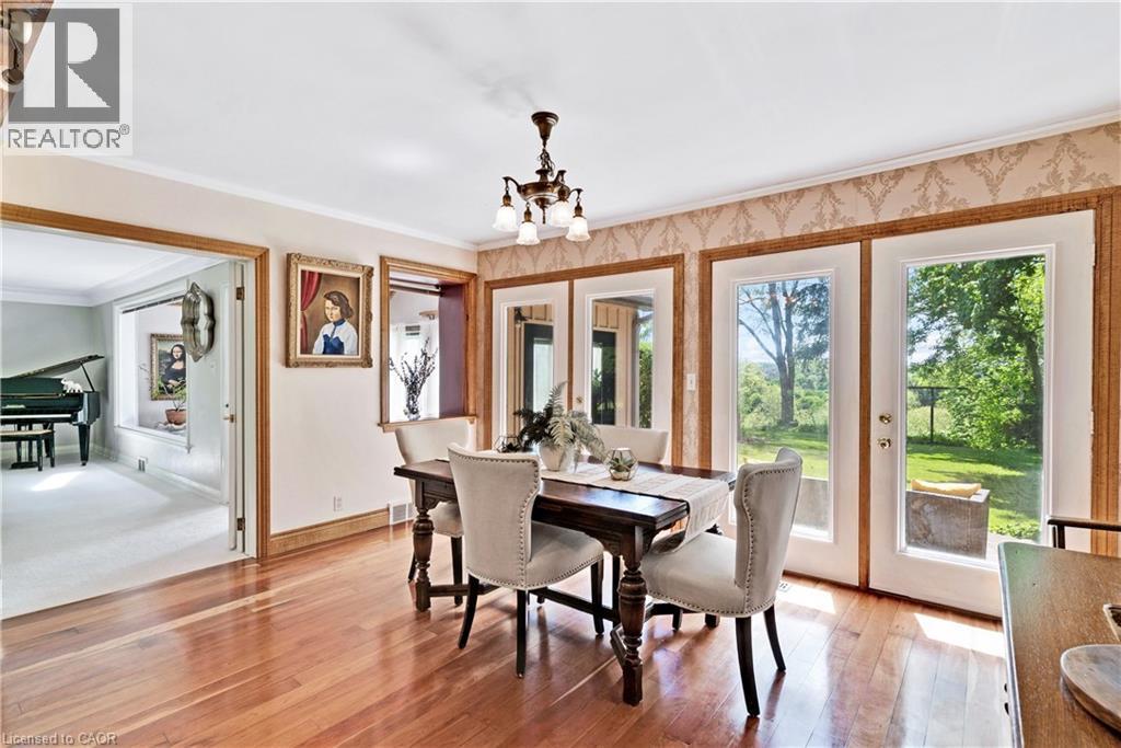 Dining area featuring wood-finish flooring, a chandelier, and decorative wall trim - 91 Limerick Drive, Kitchener, ON - Indoor Photo Showing Dining Room