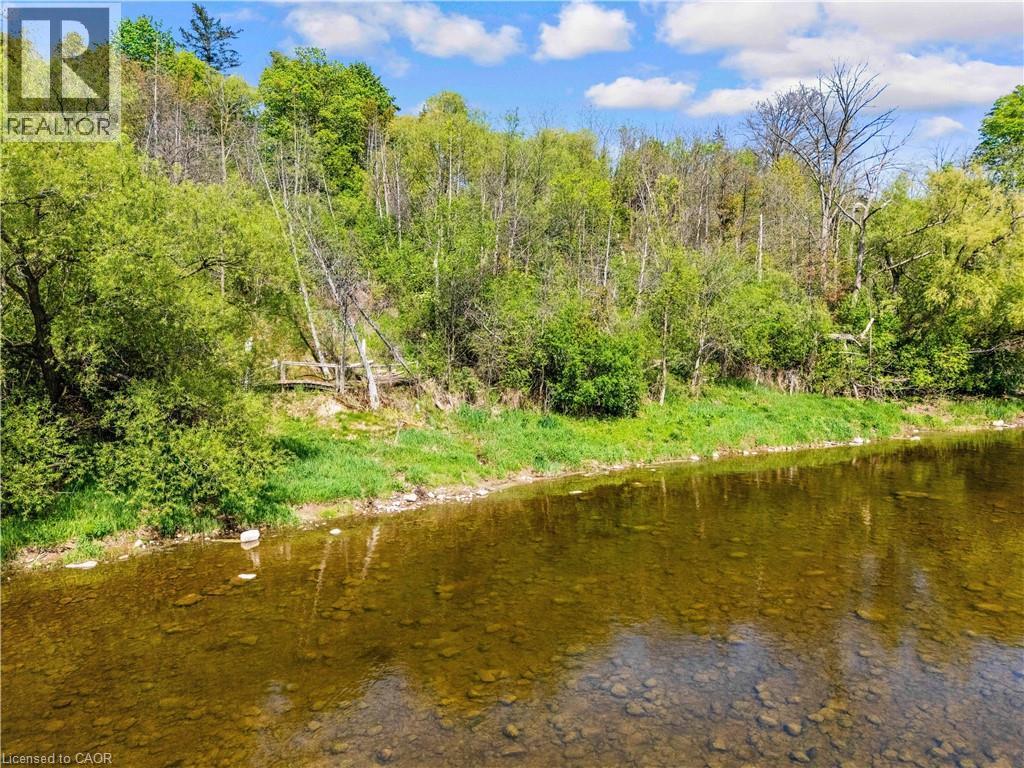 River frontage featuring clear waters, a rocky riverbed, and dense natural foliage along the bank - 91 Limerick Drive, Kitchener, ON - Outdoor With Body Of Water With View