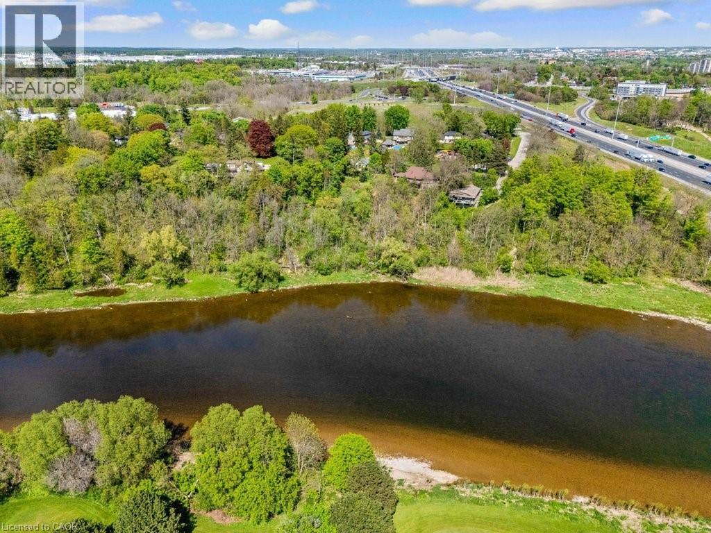 Waterfront property featuring a substantial body of water, lush green shoreline, and extensive mature trees - 91 Limerick Drive, Kitchener, ON - Outdoor With Body Of Water With View